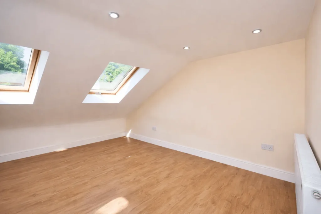 Open-plan loft conversion room with sloped ceiling in Ilford, IG1